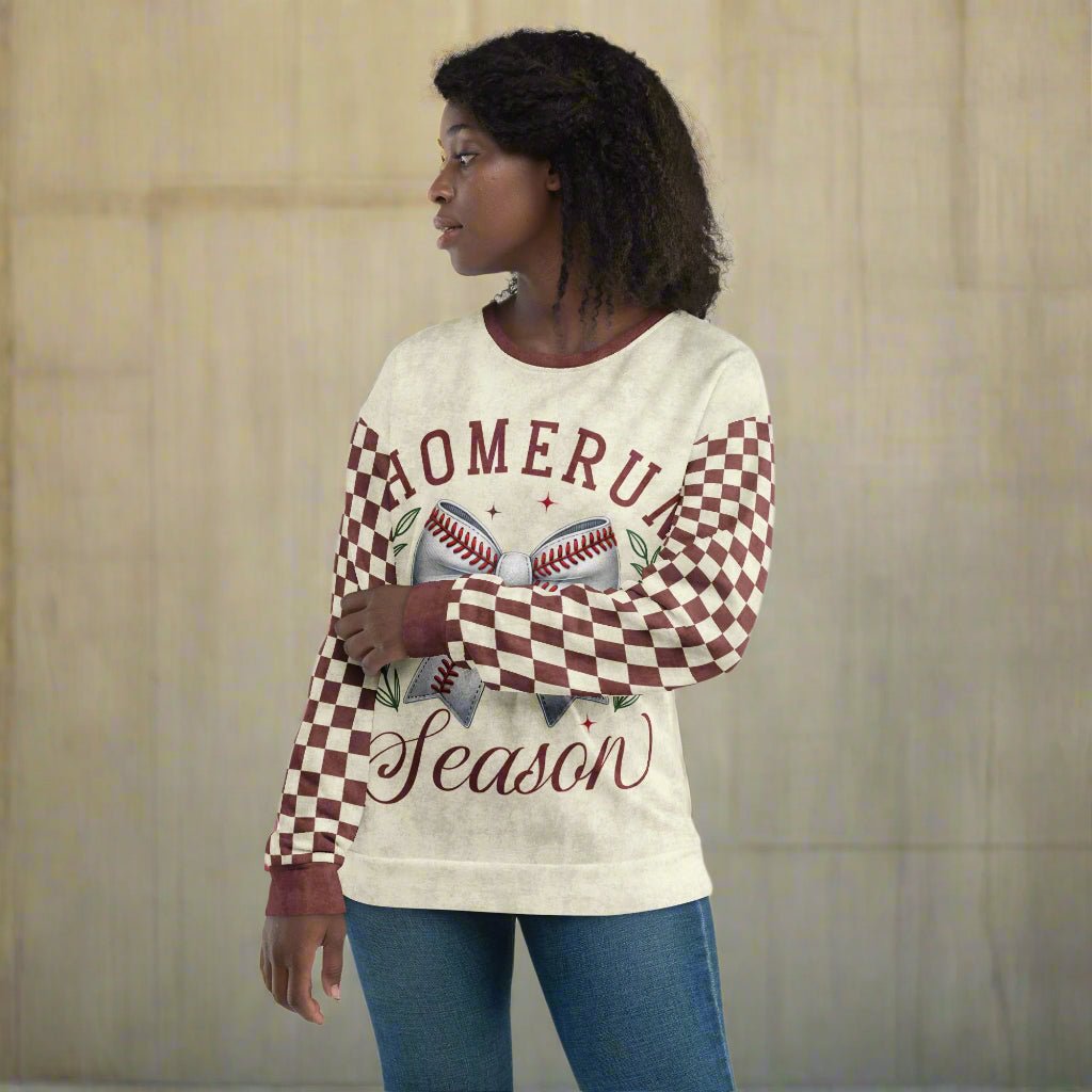 Woman wearing a sweater with 'Home Run Season' text and checkered pattern on a beige background