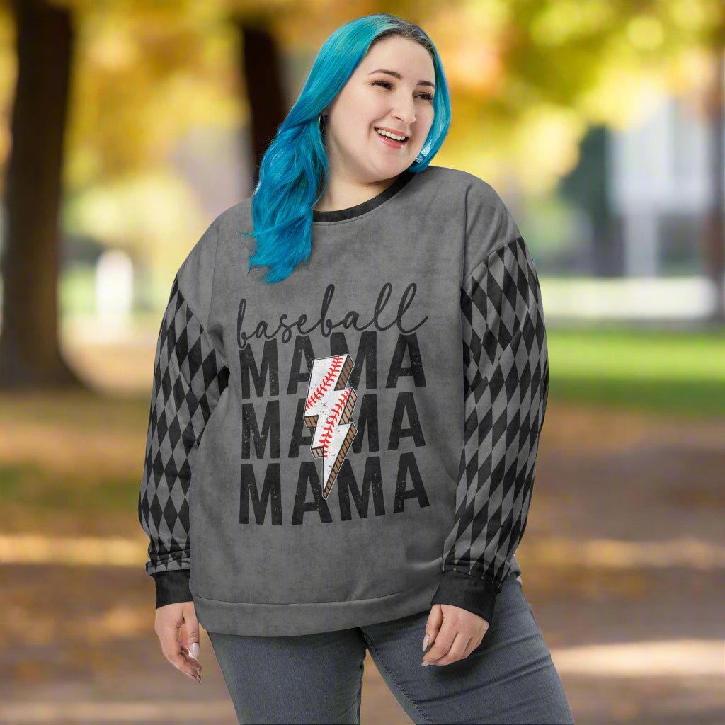 Person wearing a gray sweatshirt with 'baseball mama' text and checkered sleeves outdoors