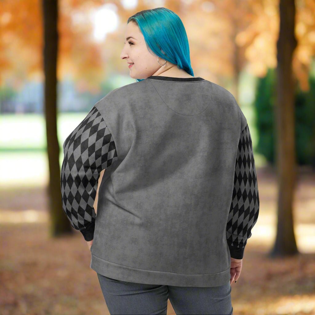 Person wearing a gray sweatshirt with black and gray patterned sleeves outdoors
