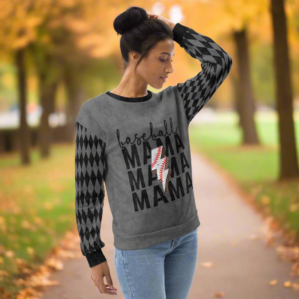 Woman wearing a gray sweatshirt with 'baseball MAMA' text and pattern outdoors