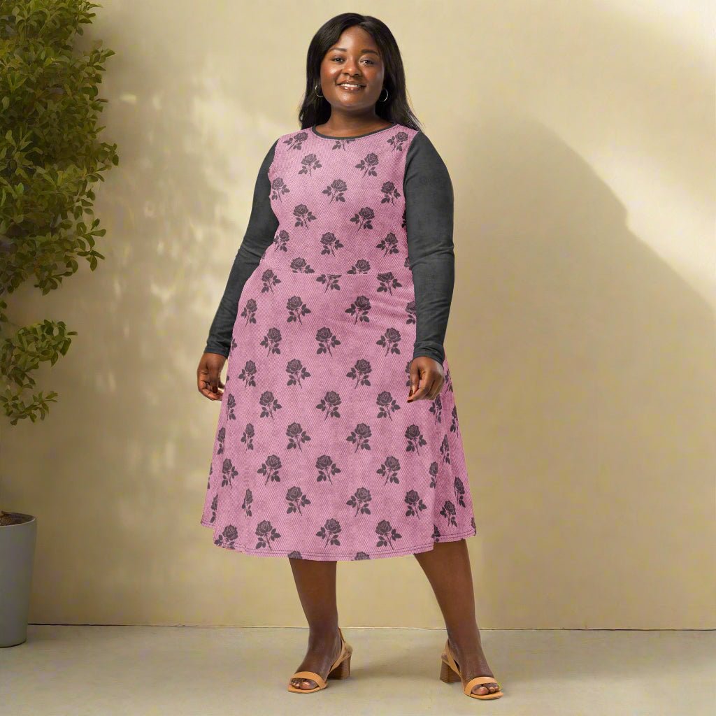 Woman wearing a pink dress with charcoal floral pattern against a neutral background