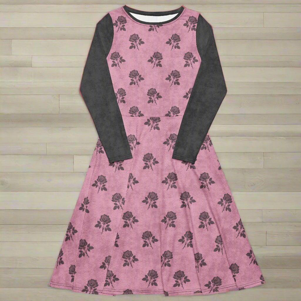Pink dress with charcoal floral pattern and long sleeves on a wood background