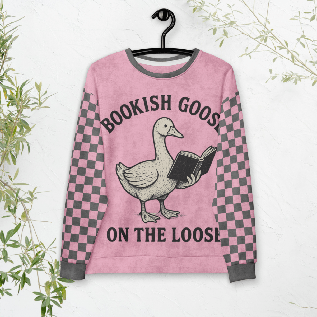 Pink sweater with a goose holding a book design and text 'Bookish Goose on the Loose' on a white background.