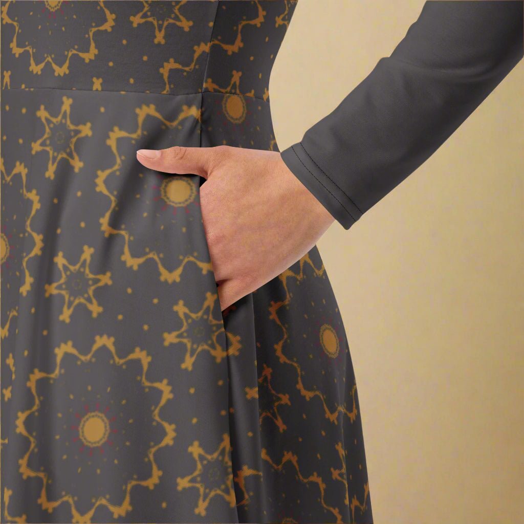 Person wearing a gray dress with gold geometric patterns against a beige background