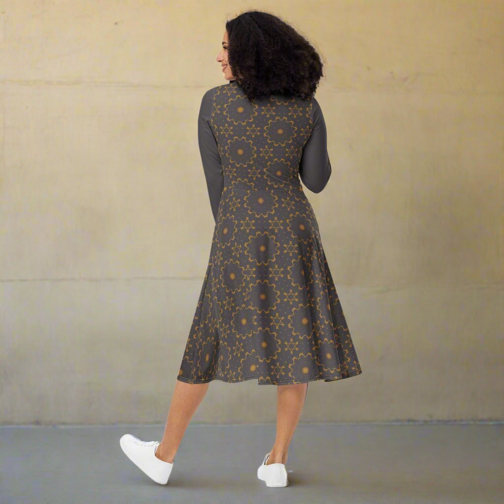 Woman wearing a patterned dress against a plain background