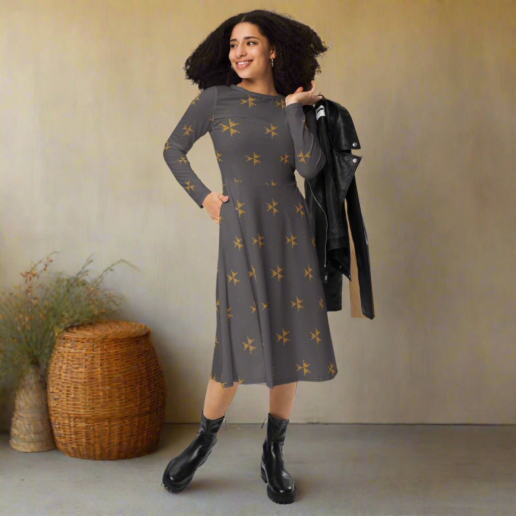 Woman wearing a gray dress with star pattern, standing against a beige wall with a woven basket and plant.