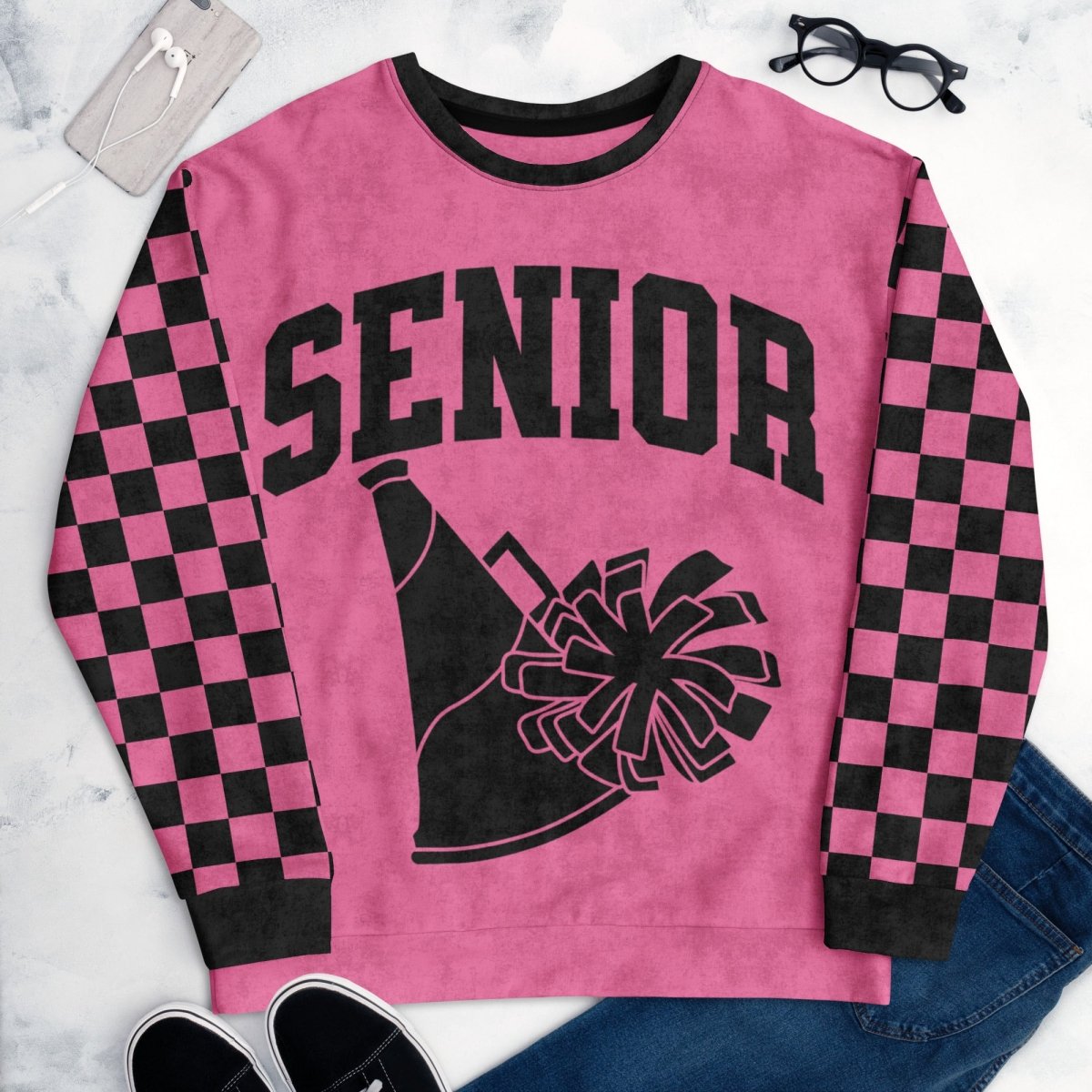 Pink sweatshirt with 'Senior' and cheerleader graphic on a marble surface.