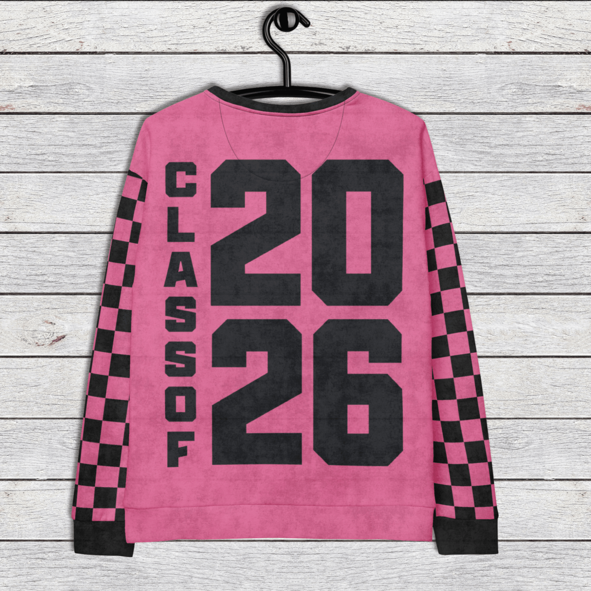 Pink sweatshirt with 'Class of 2026' text on a wooden background