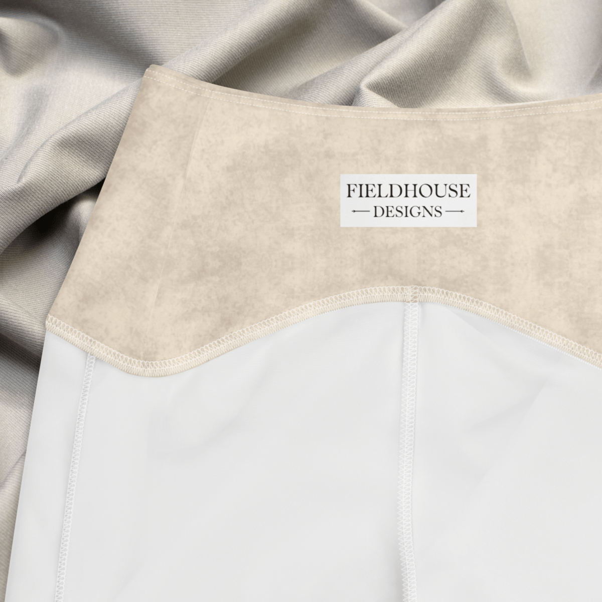 Close-up of a waistband with 'Fieldhouse Designs' label, featuring beige and white colors.