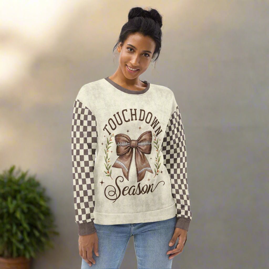 Woman wearing a sweater with 'Touchdown Season' design in a casual setting