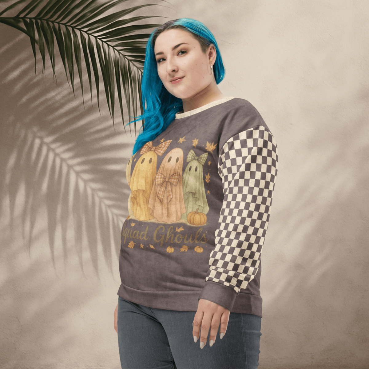 Person wearing a sweatshirt with ghost design and checkered sleeves against a beige background