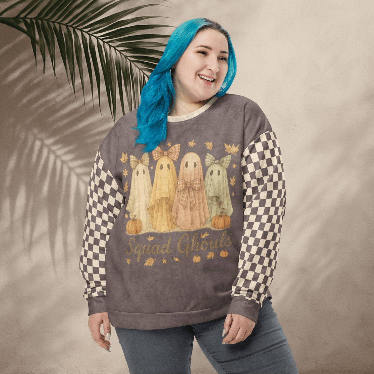 Person wearing a sweatshirt with ghost designs and 'Squad Ghouls' text, standing against a neutral background with a leaf.