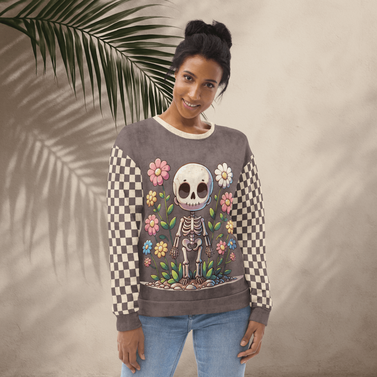 Woman wearing a sweater with a skeleton and floral design against a beige background