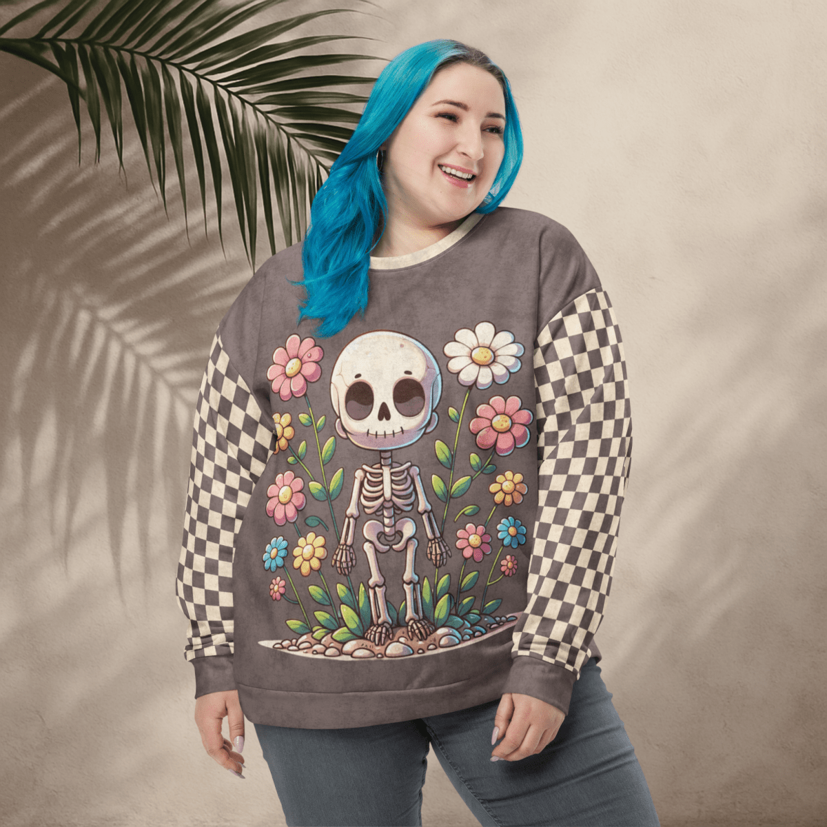 Person wearing an espresso sweatshirt with a skeleton and floral design, standing against a beige background with a palm leaf.