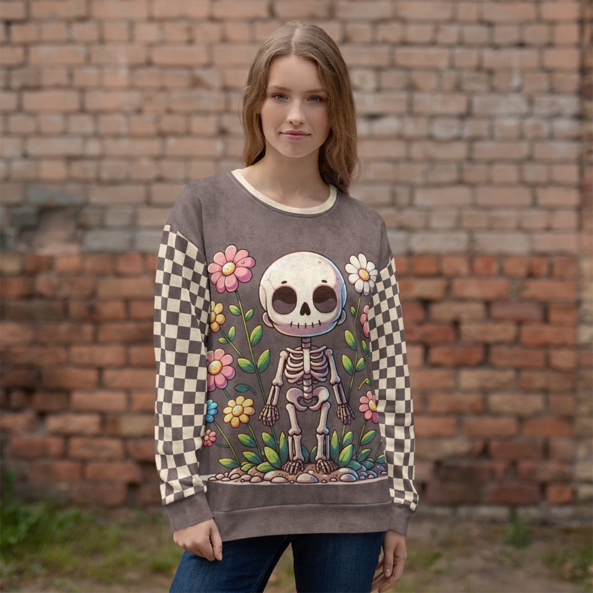 Person wearing a checkered sleeve sweater with a skeleton design in front of a brick wall