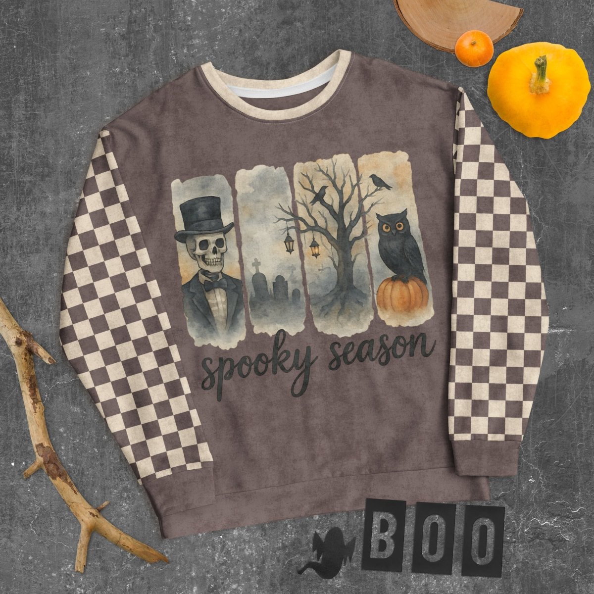 Sweatshirt with Halloween-themed design featuring an owl, pumpkin, and text on a checkered background.