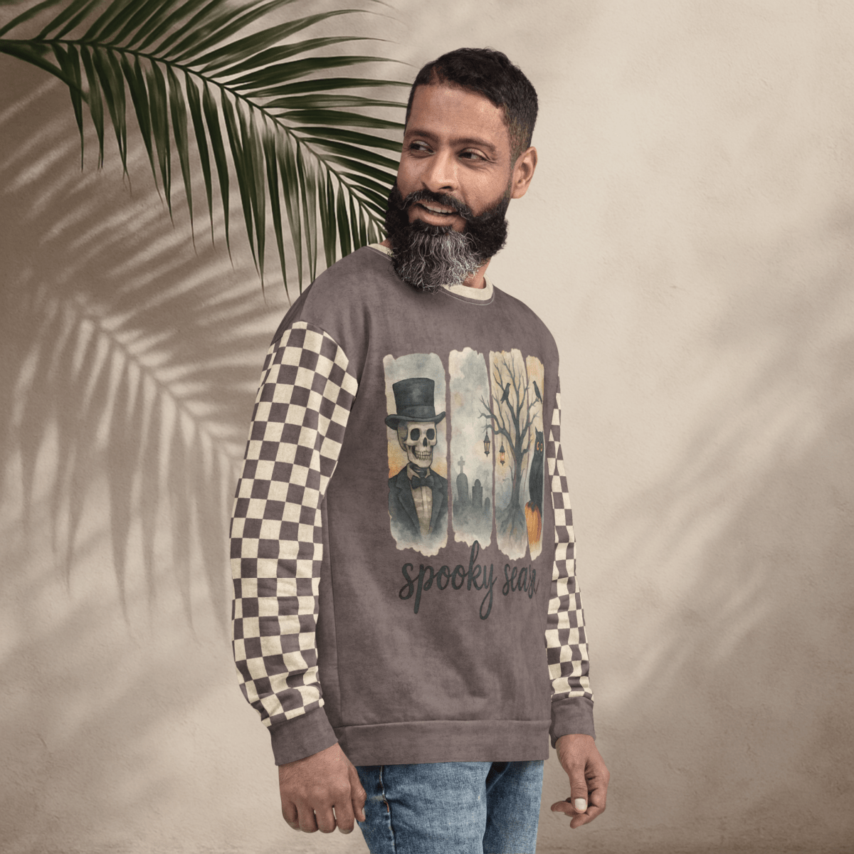 Man wearing a sweater with a graphic design and text, standing against a beige background with a leaf.