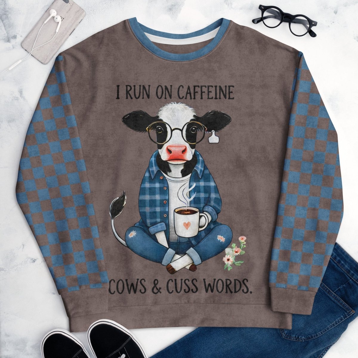 Espresso and denim Sweatshirt with a cow graphic and text on a marble surface