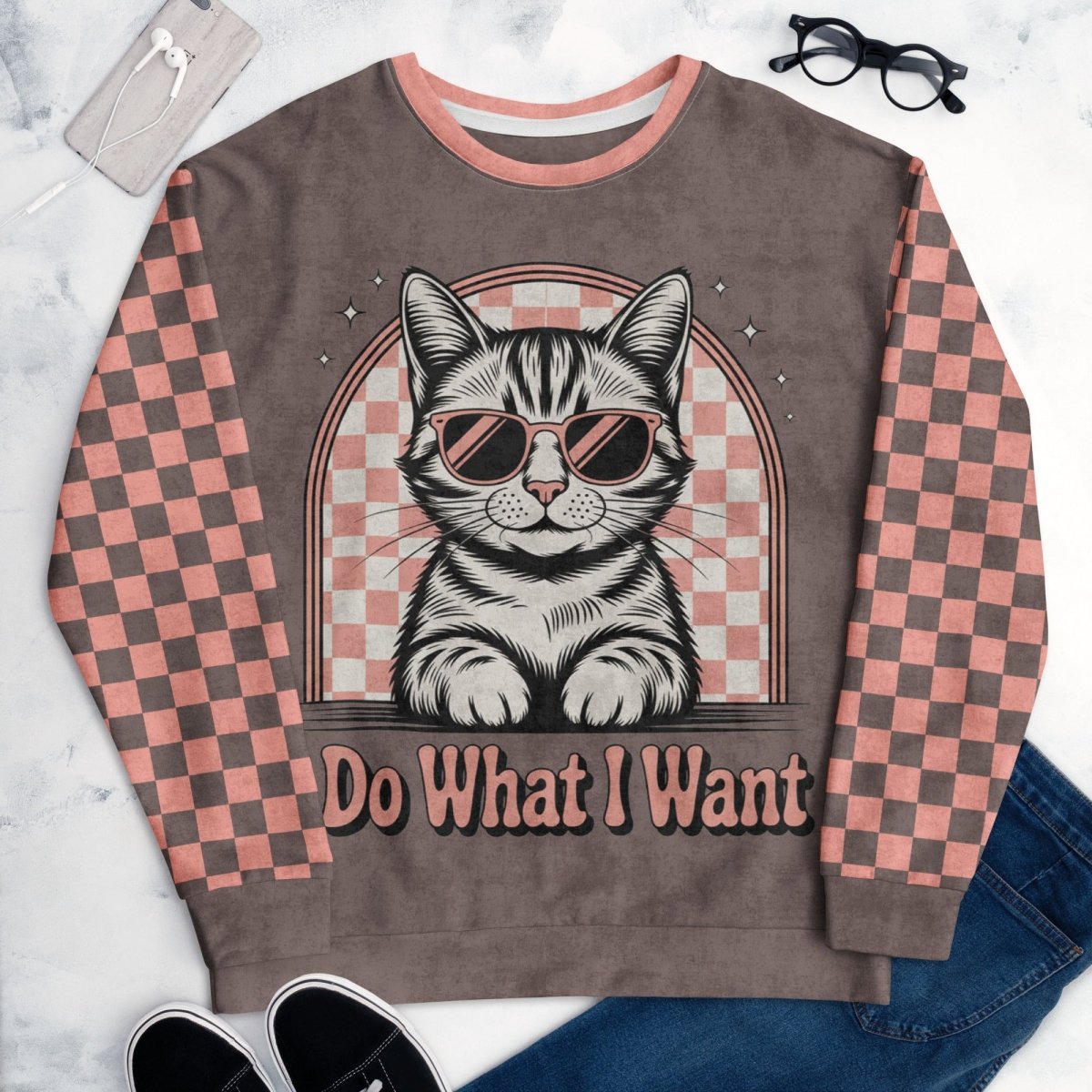 Espresso sweatshirt with a sunglasses-wearing tabby cat and “I Do What I Want” text; sleeves feature pink-and-espresso checkerboard pattern with pink collar and cuffs.