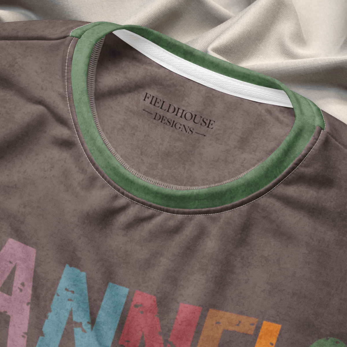 Close-up of a shirt with 'Fieldhouse Designs' branding on a fabric background
