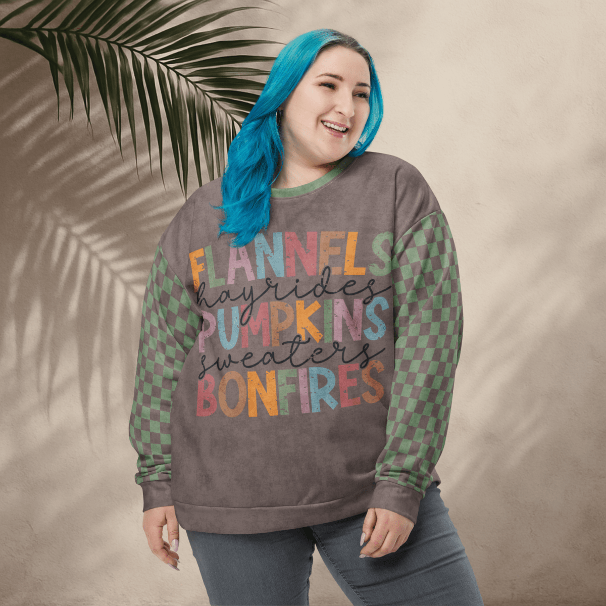Person wearing an Espresso and sage green sweater with colorful text against a beige background
