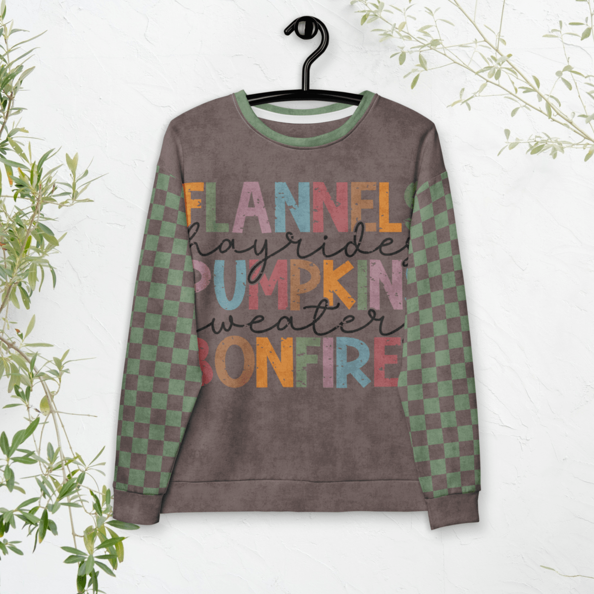 Espresso and sage green Sweatshirt with colorful text and checkered sleeves on a hanger against a white background