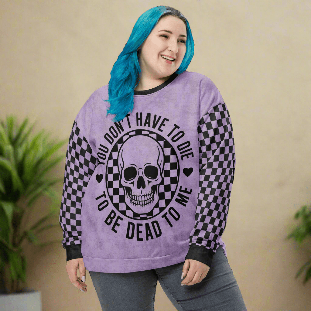 Person wearing a purple sweatshirt with a skull design and text on a beige background