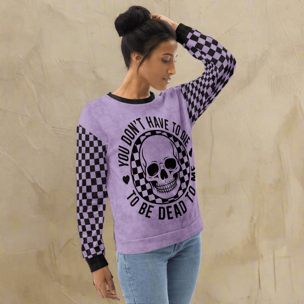 Woman wearing a purple sweatshirt with a skull design and text on a white background