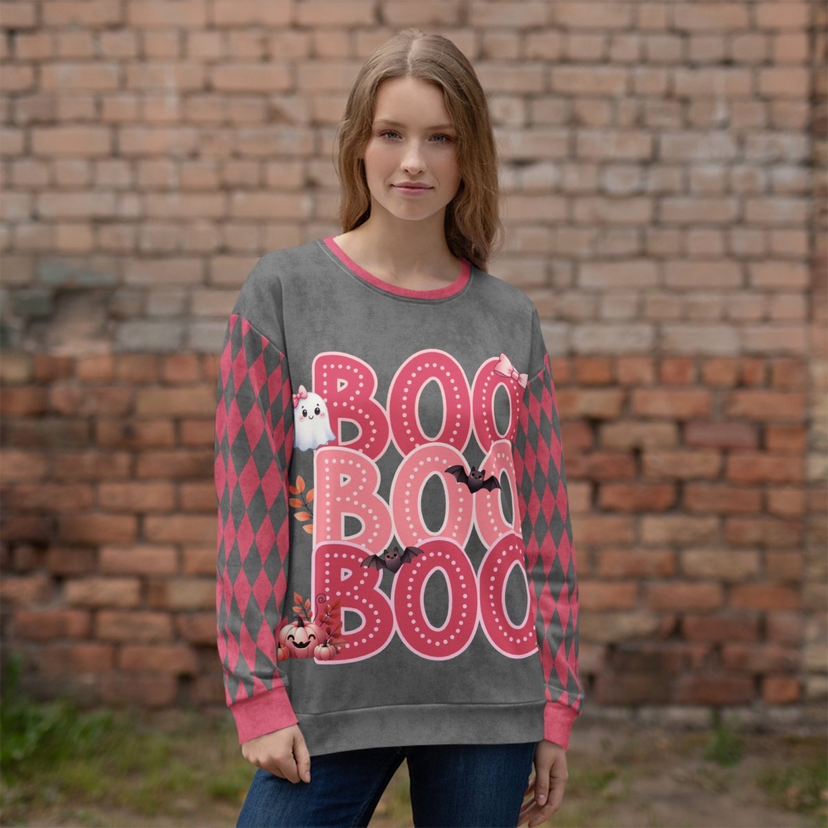 Person wearing a Halloween-themed sweater with 'BOO' text and graphics against a brick wall.