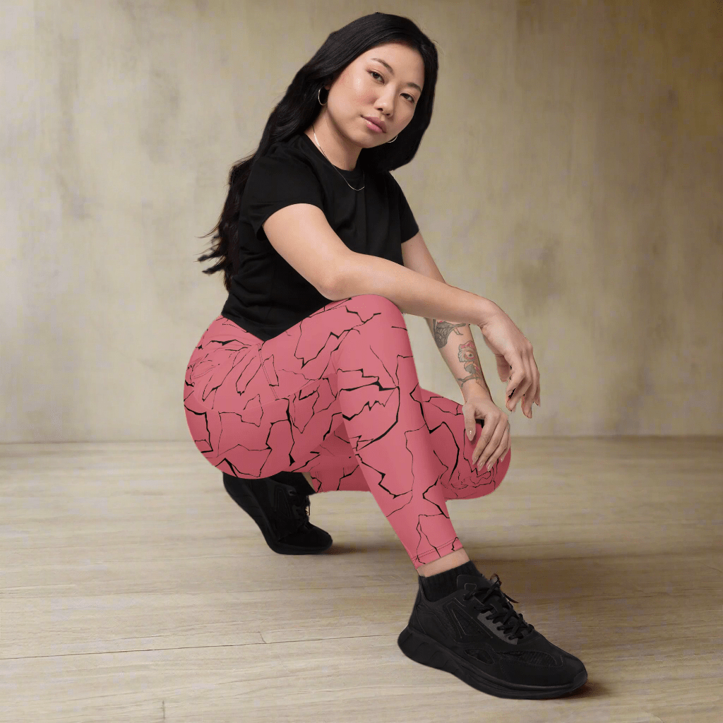 Person wearing pink patterned pants and black shoes on a neutral background