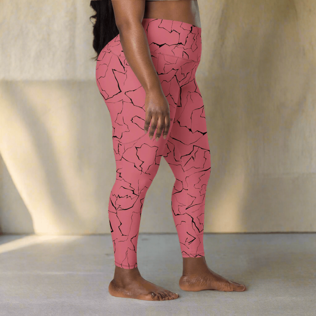 Pink leggings with black pattern worn by a person on a neutral background