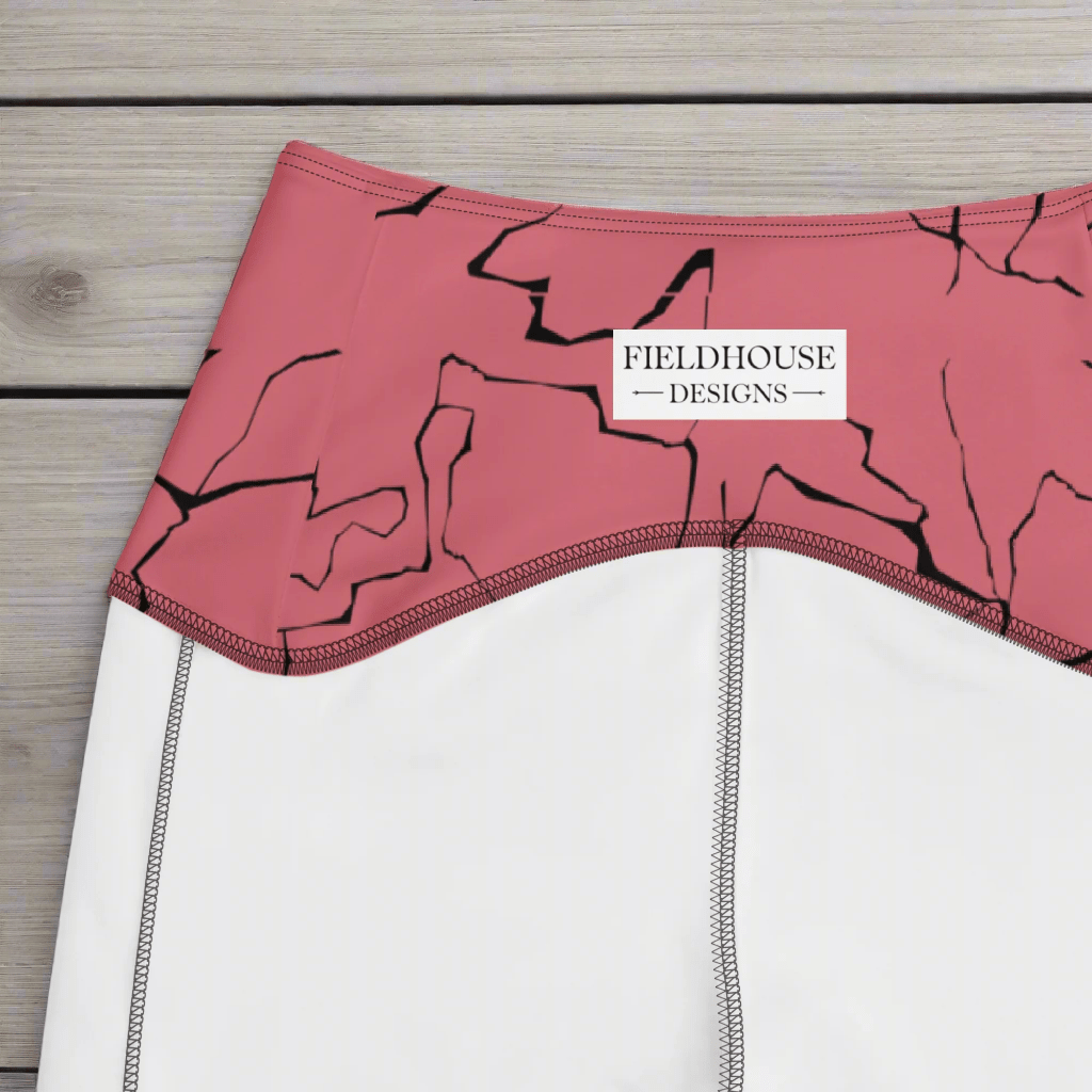 Close-up of a pink and black patterned waistband on a wooden surface, featuring 'Fieldhouse Designs' branding.