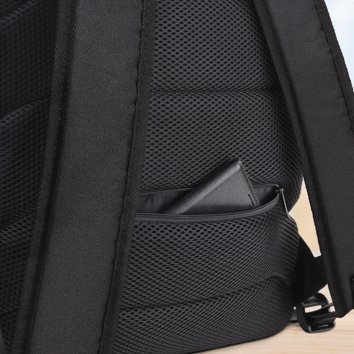 Close-up of a backside of a backpack with mesh design on a light wooden surface