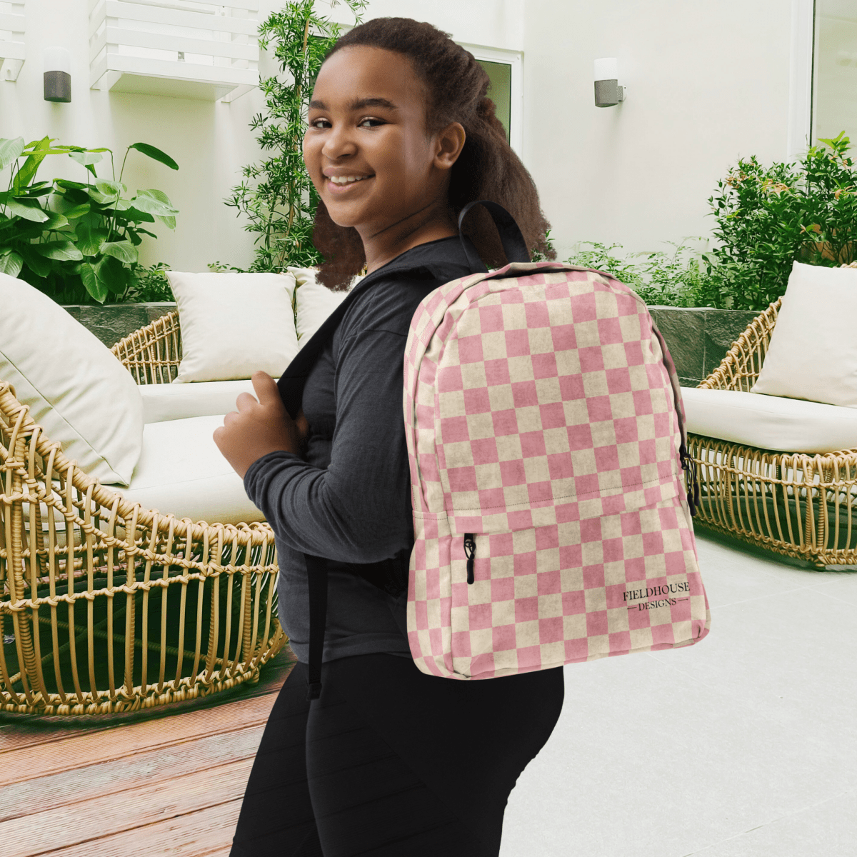 Person wearing a pink checkered backpack in an outdoor setting