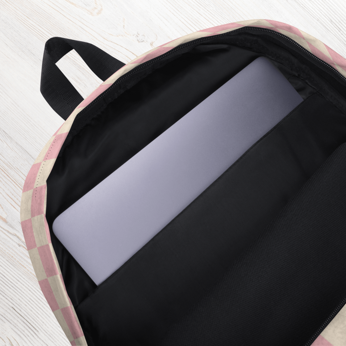 Backpack with a laptop inside on a light wooden surface