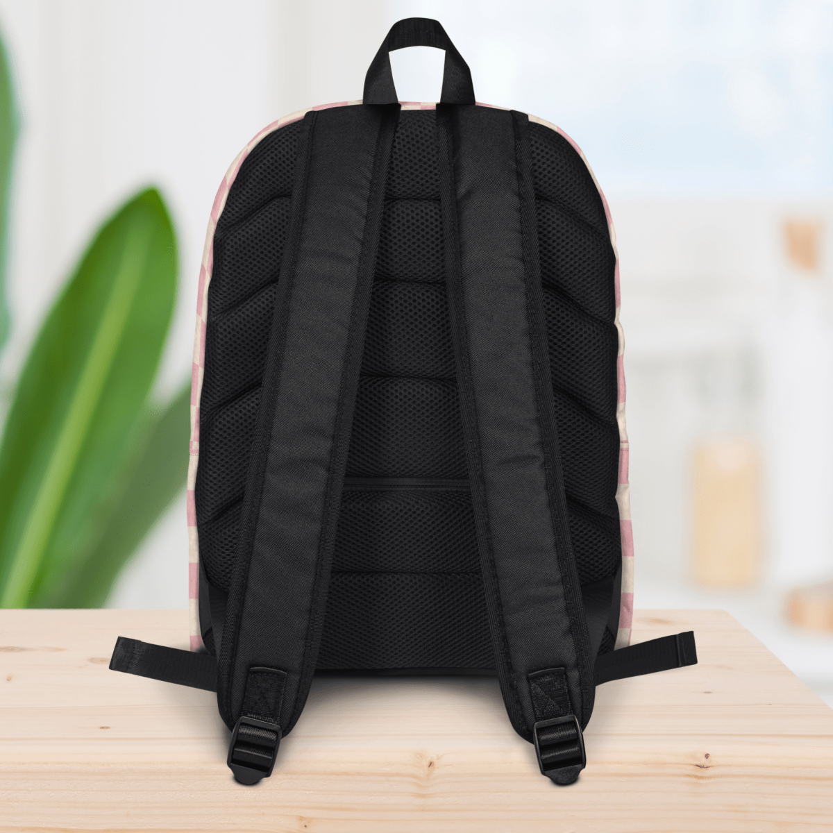 Backside of a backpack on a wooden surface with a blurred background