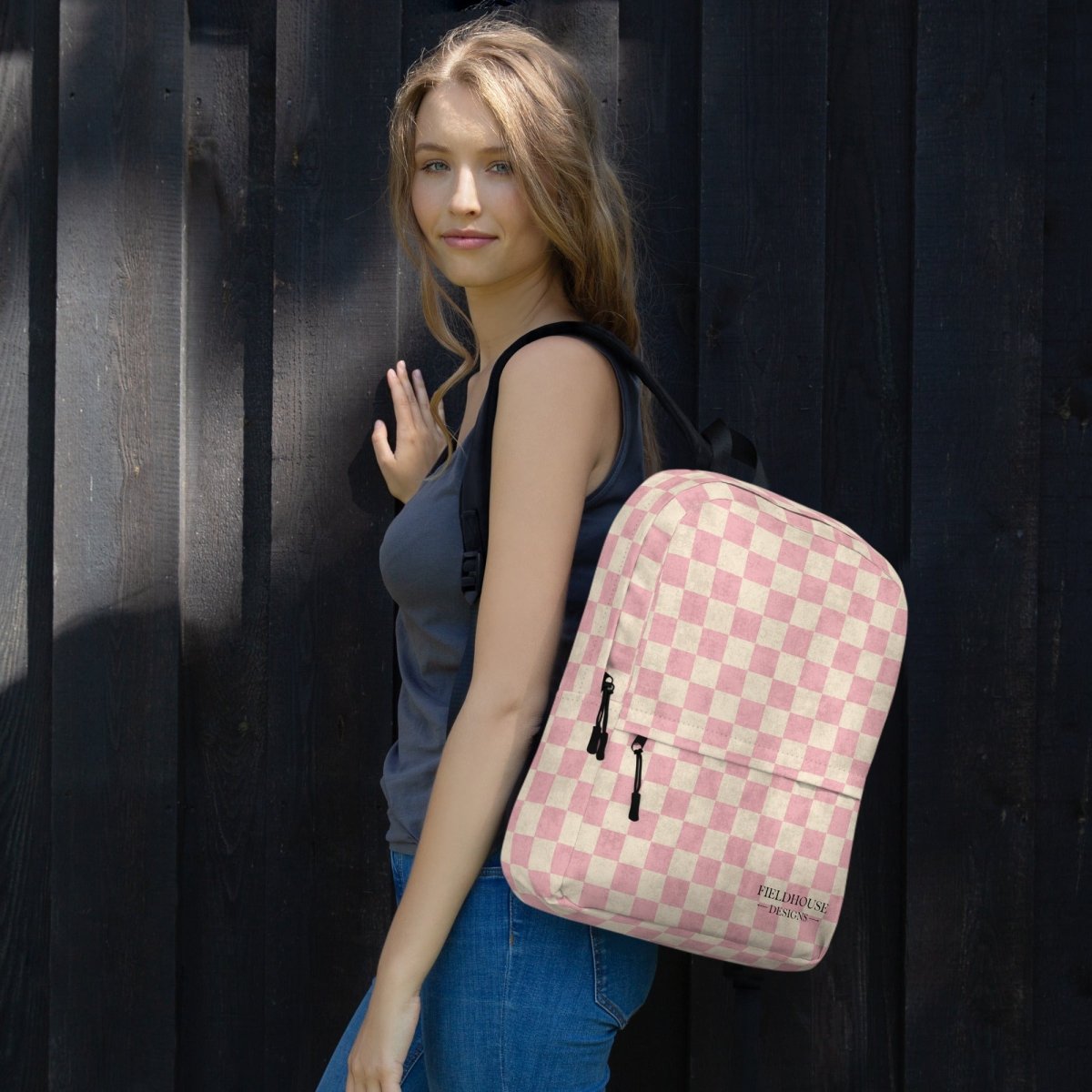 Woman with a pink and white checkered backpack against a dark background