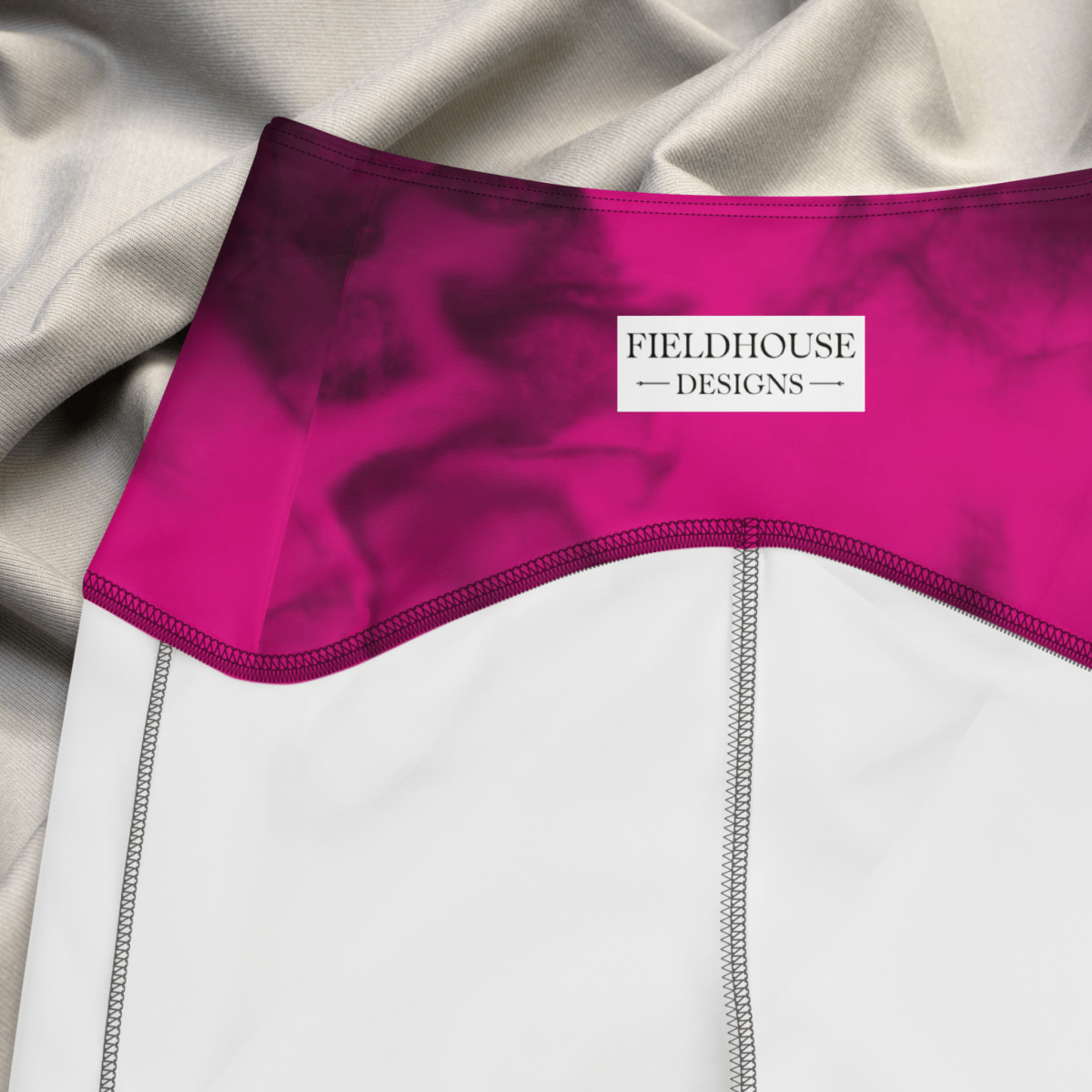 Close-up of a garment with a pink waistband and 'Fieldhouse Designs' label.
