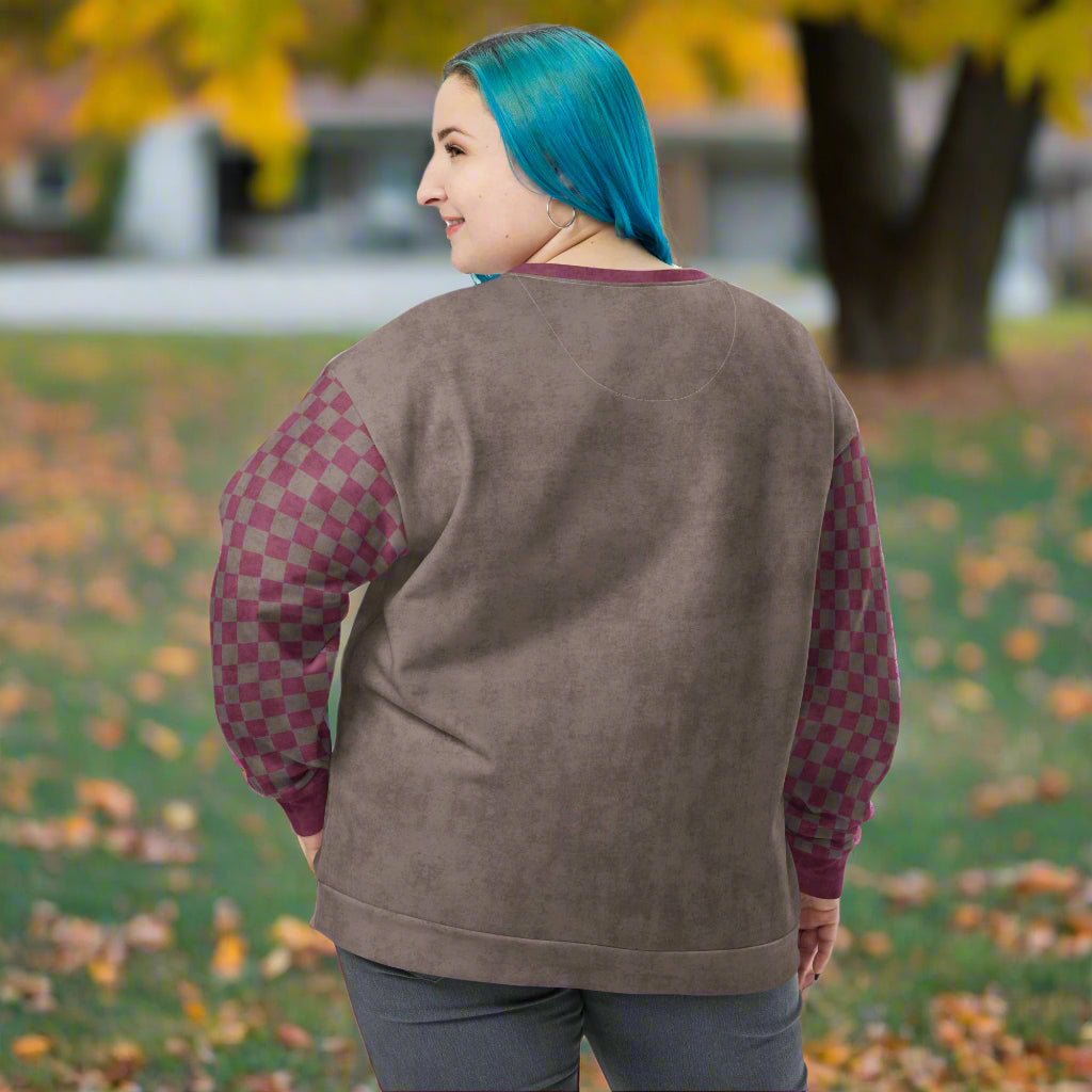 Person wearing an espresso sweatshirt with checkered sleeves outdoors