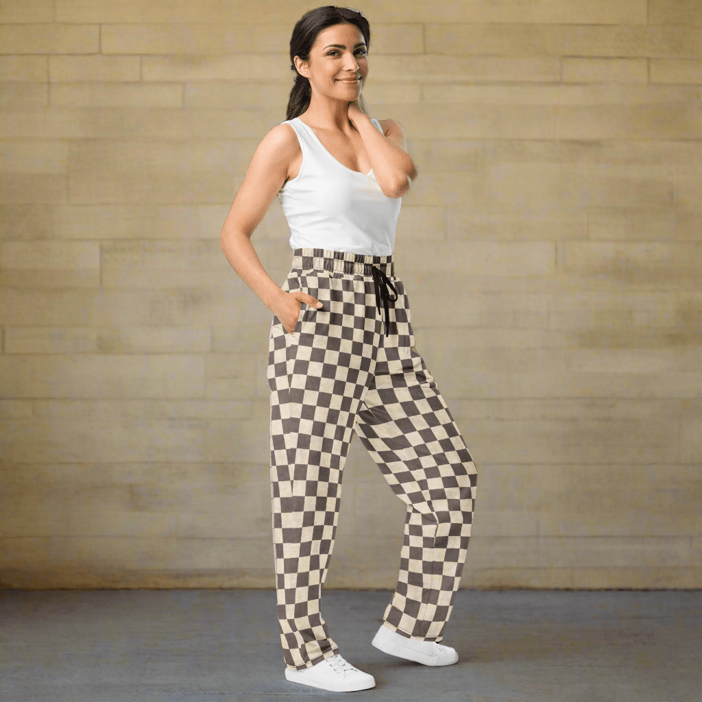 Woman wearing checkered pants on a neutral background