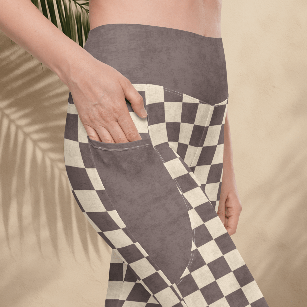 Person wearing espresso checkered pocket leggings with a beige background