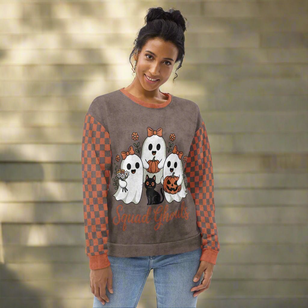 Woman wearing a Halloween-themed sweater with ghosts and checkered sleeves against a stone wall background.