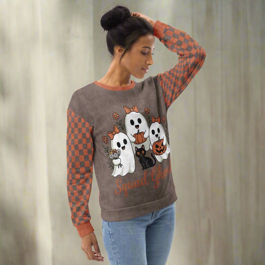 Woman wearing a Halloween-themed sweater with ghost and cat designs.