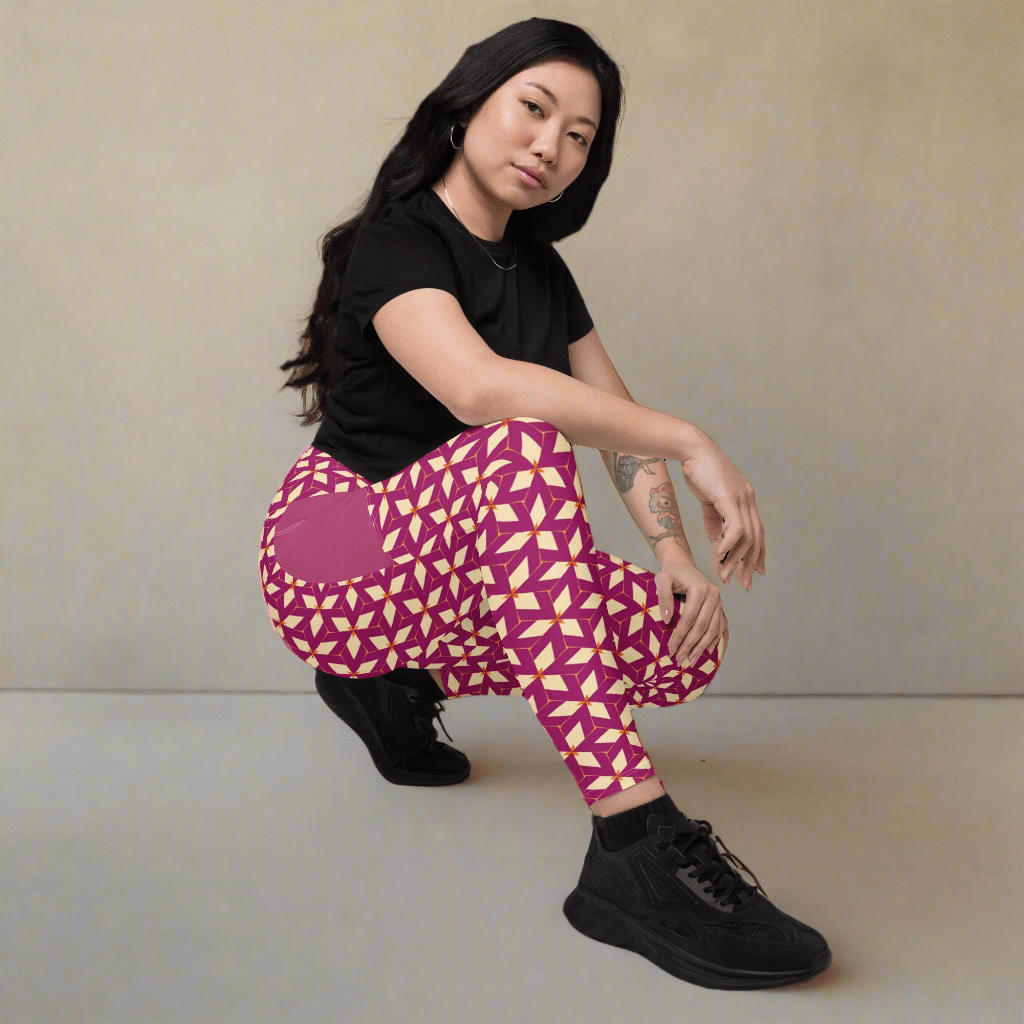 Person wearing a black top and purple geometric-patterned pants on a plain background