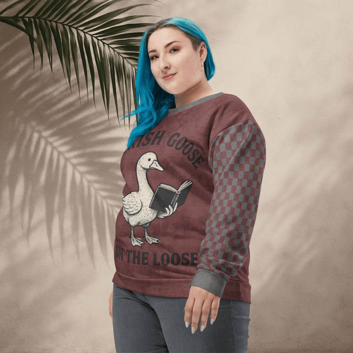 Person wearing a sweatshirt with a goose graphic and text against a beige background