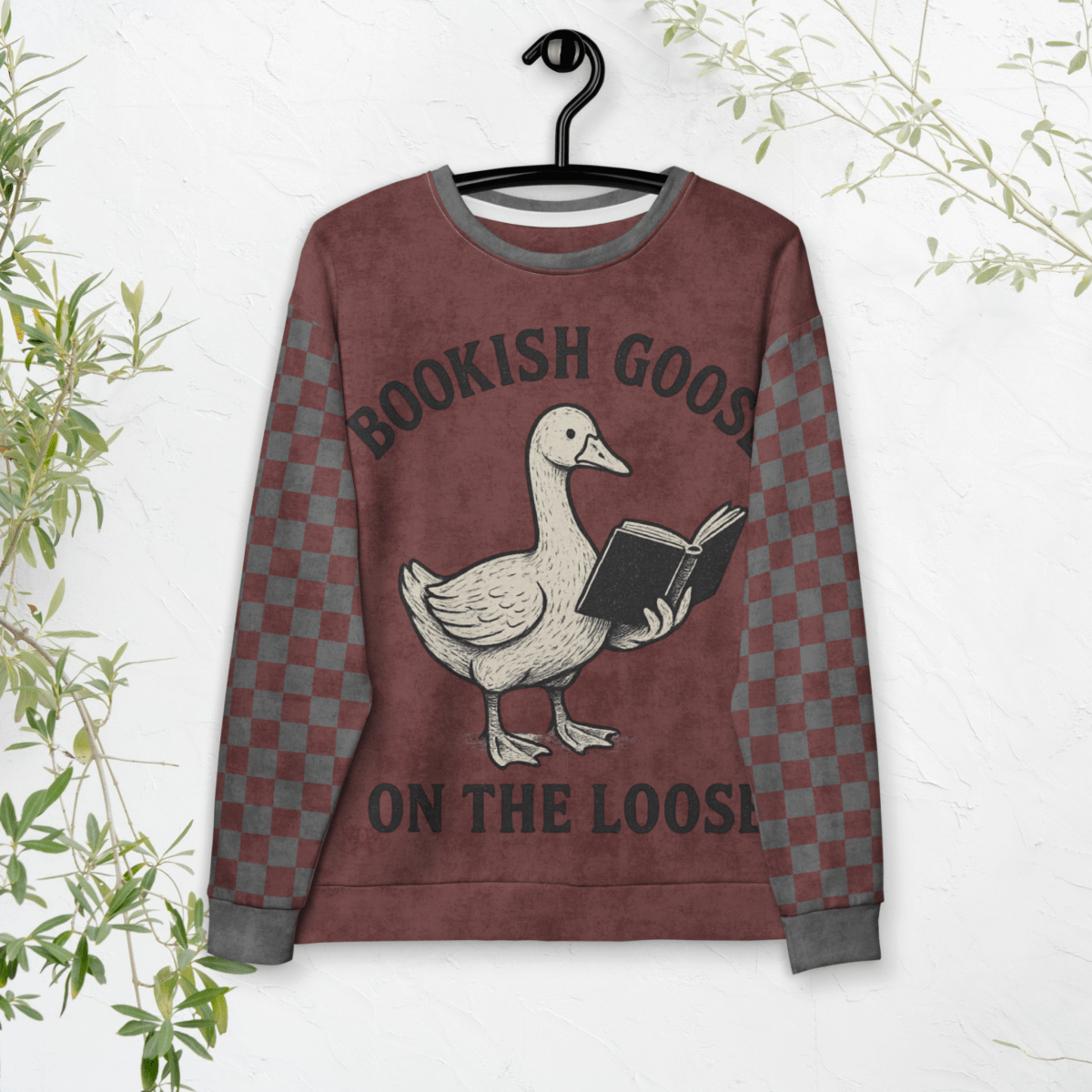 Sweatshirt with a goose holding a book design and text 'Bookish Goose on the Loose' on a hanger against a white background.