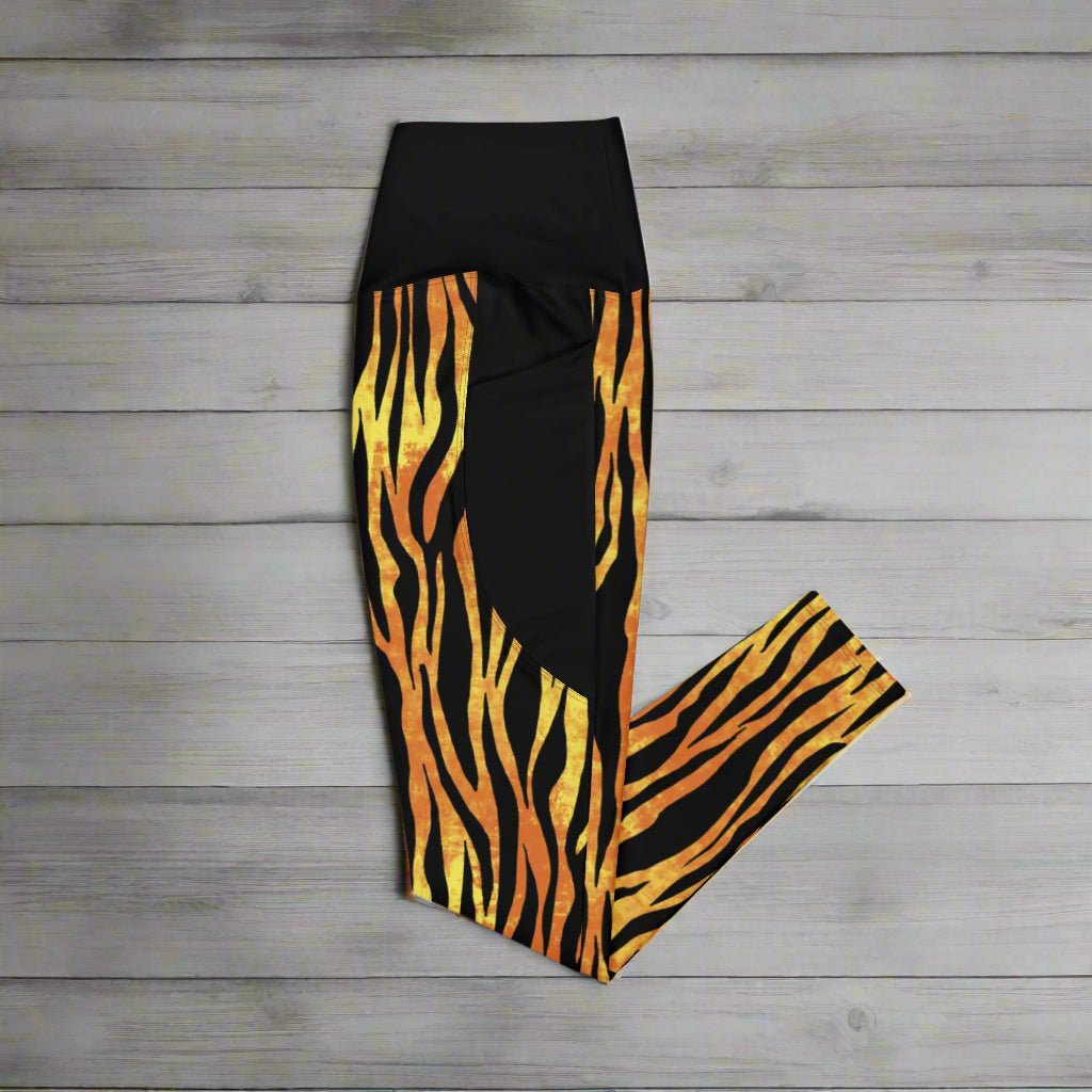 Black leggings with orange and yellow zebra pattern on a wood background