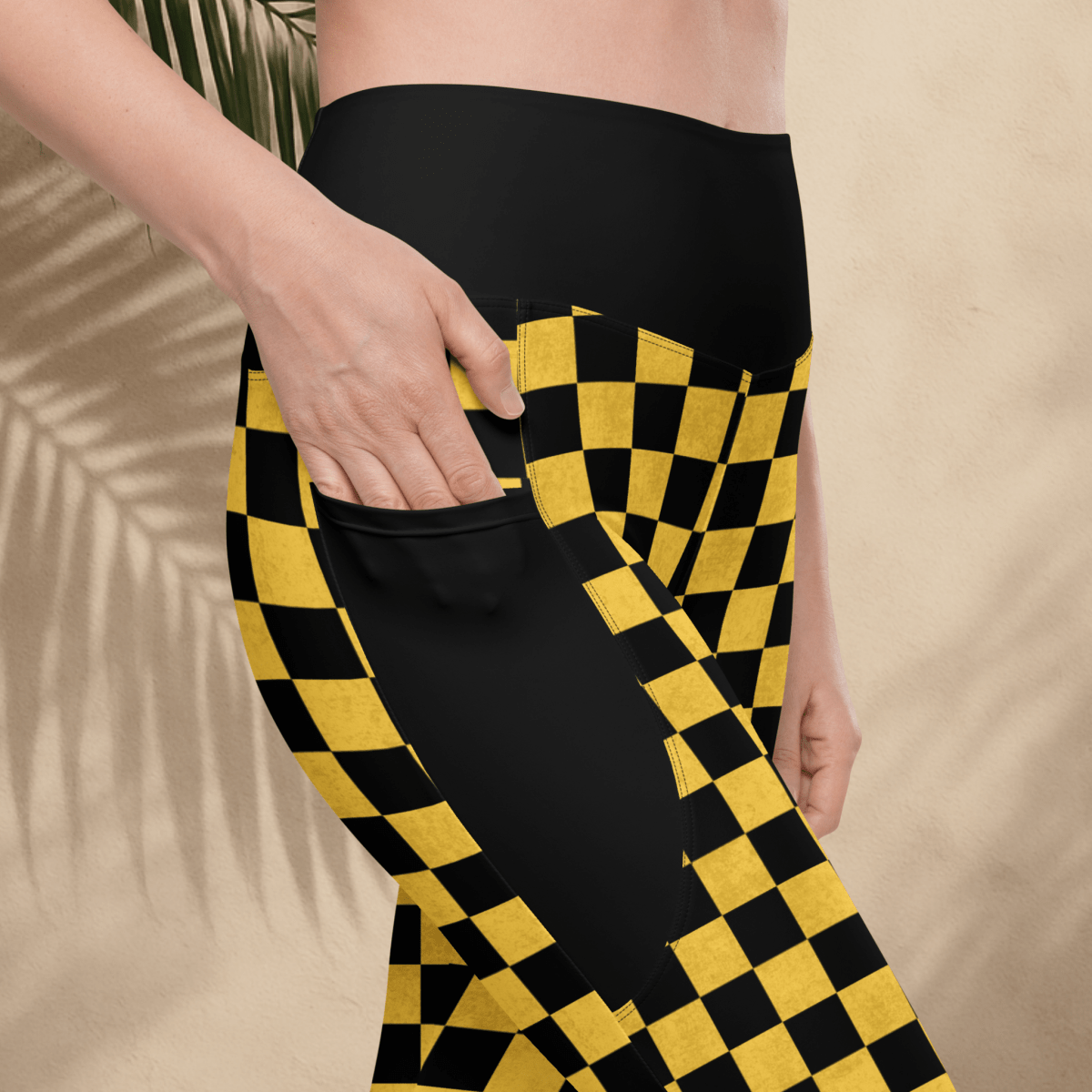 Person wearing black and yellow checkered pants on a beige background