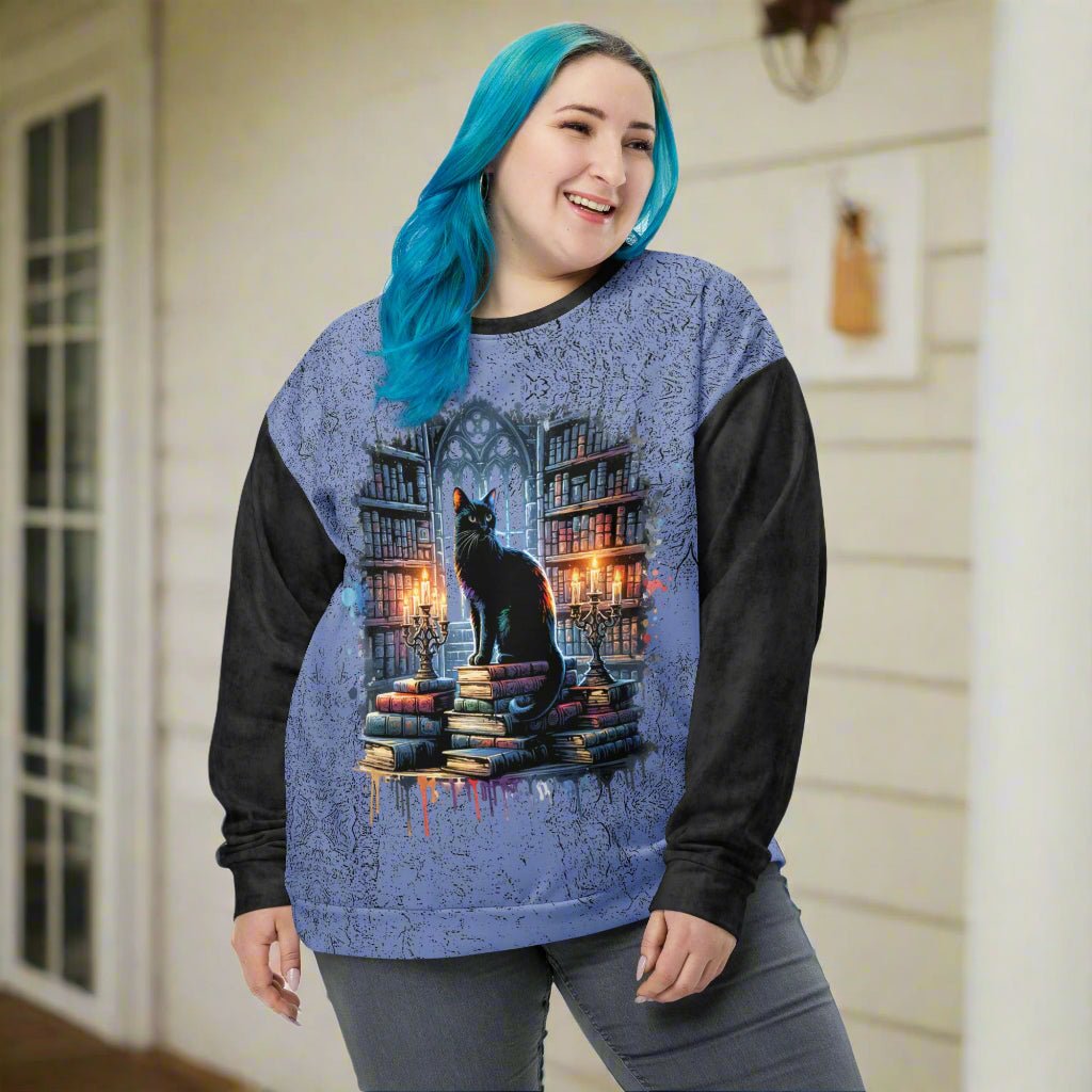 Person wearing a sweater with a cat and books design on a white background