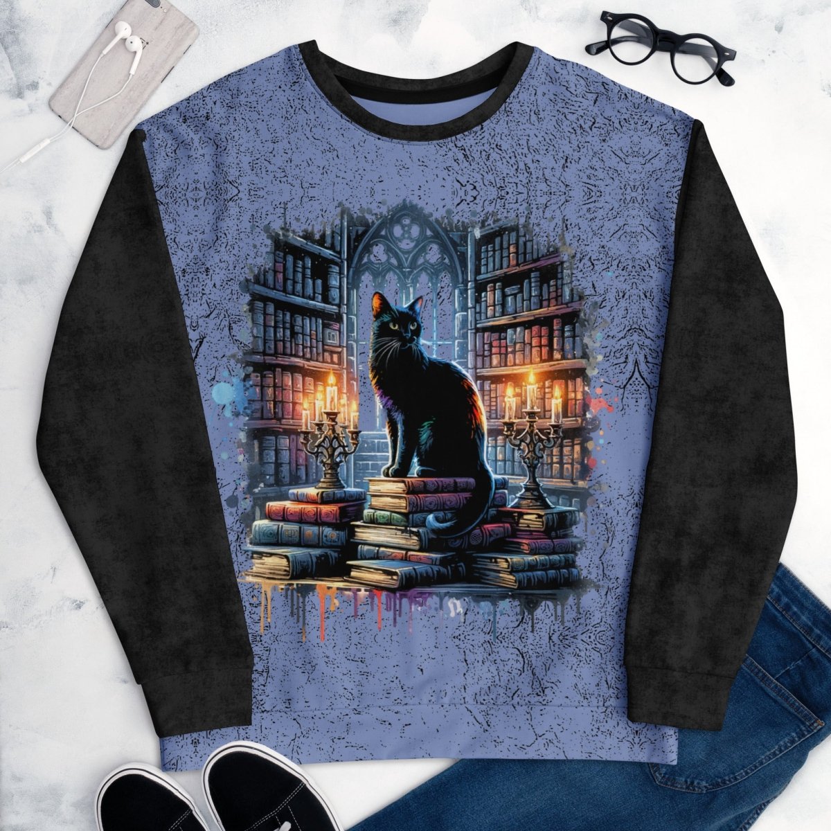 Long-sleeve sweatshirt with a cat on books design on a marble surface.